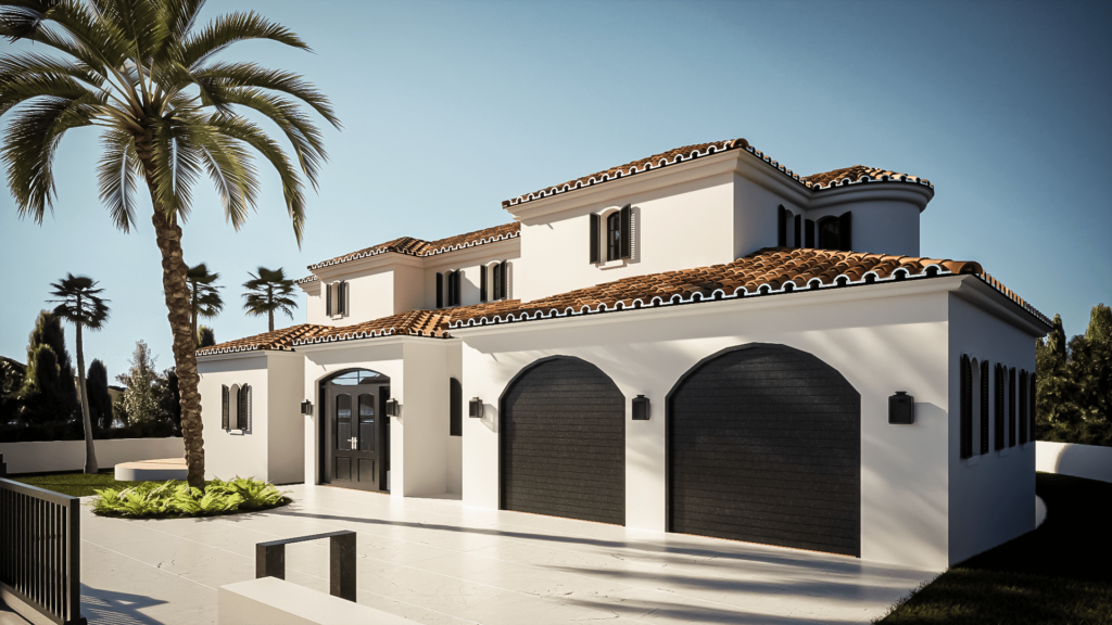 The image shows a Mediterranean-style villa with smooth white stucco walls and terracotta roof tiles. The house features multiple arched windows and doors, with one prominent rounded turret-like section that includes a balcony with wrought iron railings. The villa has a spacious outdoor patio area with steps leading up to it and is surrounded by greenery, including a few palm trees in the background. The overall design is elegant and luxurious, highlighting a blend of traditional Mediterranean and modern architectural elements